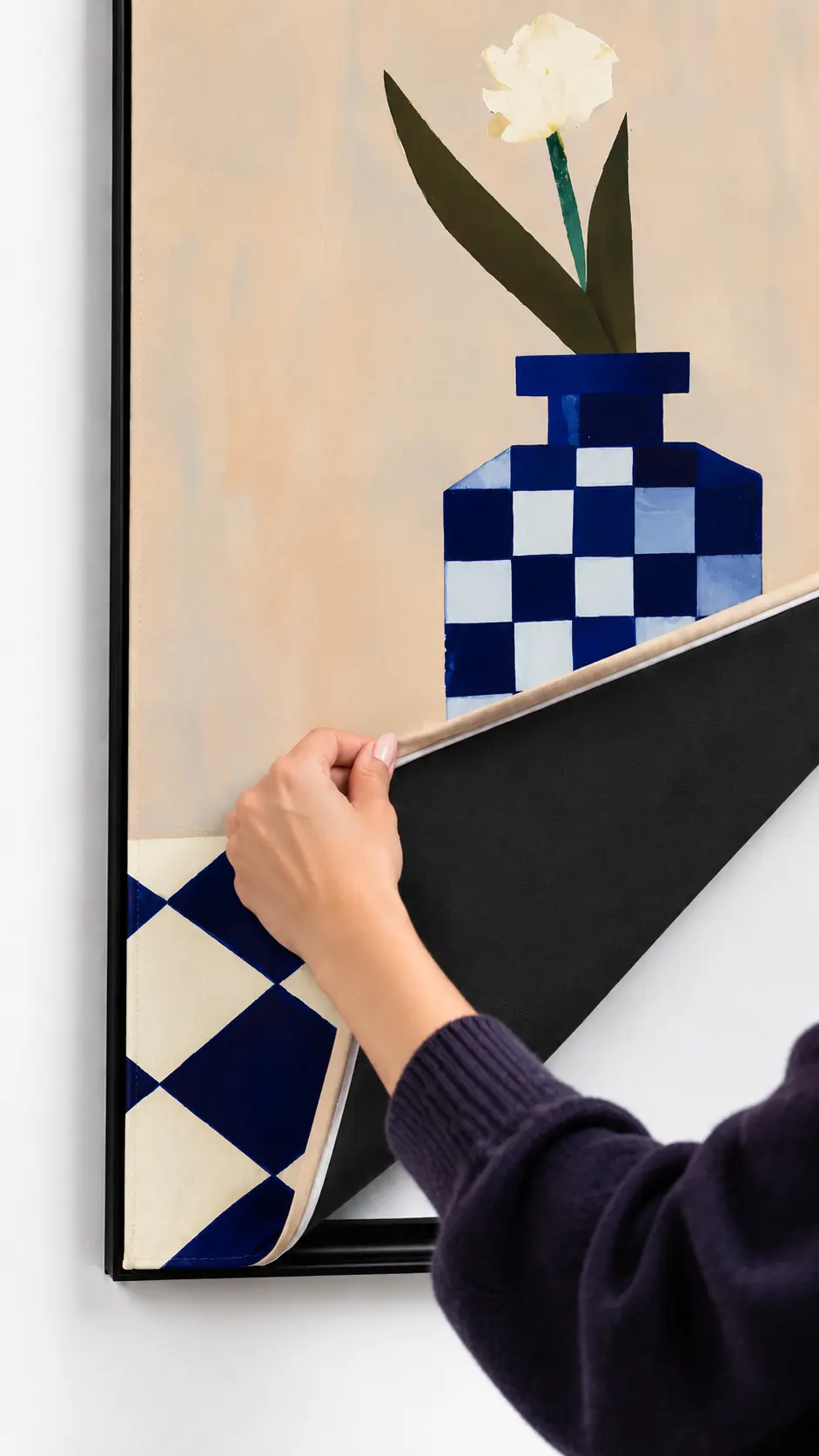 A hand pulling the Swappable Print out of a black frame