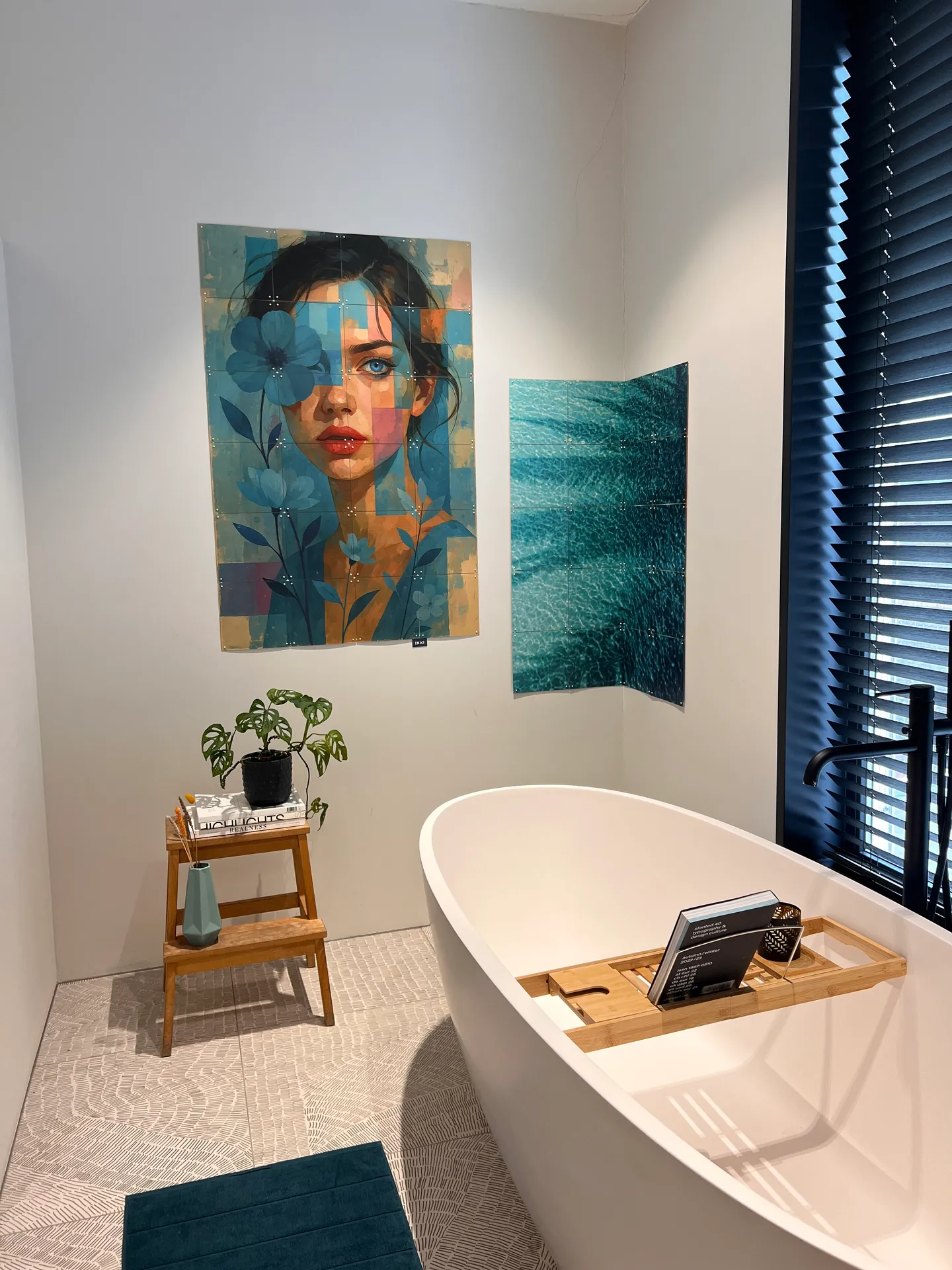 Een IXXI van een vrouwenportret met blauwe bloemen naast een zeegroen ontwerp, in de badkamer