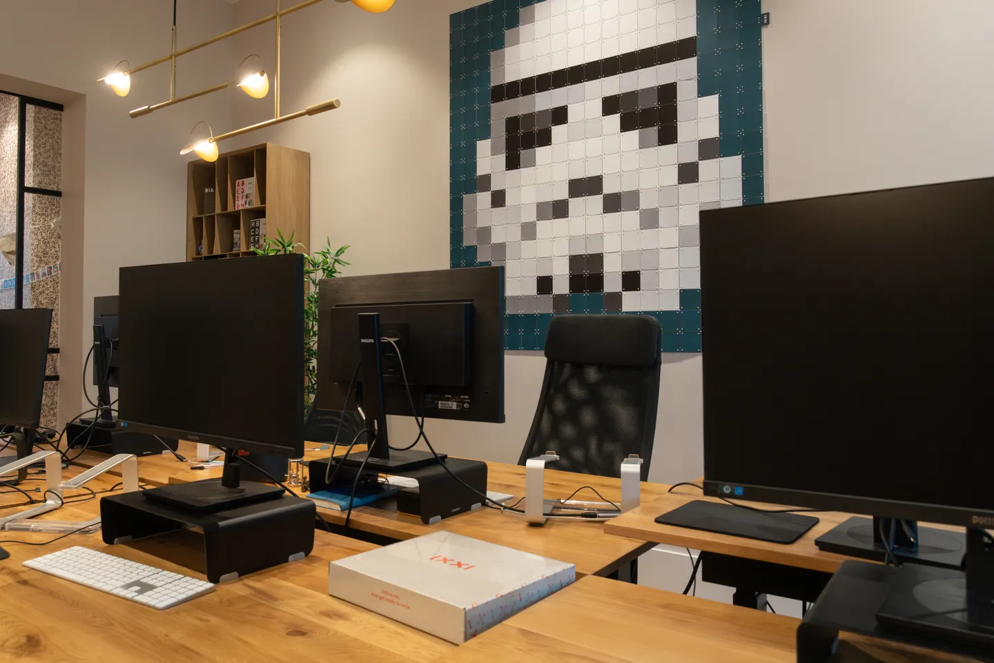Werkplek met beeldschermen en een IXXI van een stormtrooper aan de wand